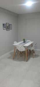 une table et deux chaises dans une pièce blanche dans l'établissement El Descanso, à Ezeiza