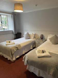 a bedroom with two beds with towels on them at The Kings Arms Inn in Yeovil