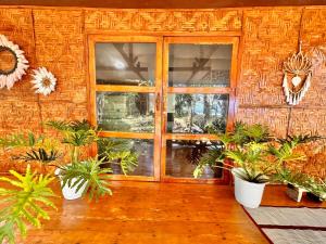 une chambre avec une porte et un bouquet de plantes dans l'établissement Playa del Fuego Camiguin Beach Hostel & Resort, à Mambajao