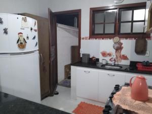 a kitchen with a white refrigerator and a counter at Cantinho da Margarete in Santa Cruz Cabrália