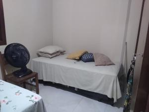 Cantinho da Margarete في سانتا كروز كابراليا: سرير صغير عليه وسائد في الغرفة