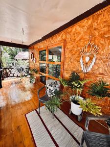 una habitación con una pared de madera con plantas. en Playa del Fuego Camiguin Beach Hostel & Resort, en Mambajao