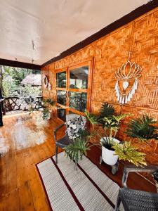 a room with a wooden wall with plants on it at Playa del Fuego Camiguin Beach Hostel & Resort in Mambajao