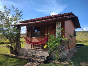 a small house in the middle of a field at Pousada Ceu e Serra in Carrancas