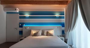 ein Schlafzimmer mit einer blau-weißen gestreiften Wand in der Unterkunft Stella del Garda in Lazise