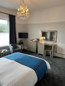 a bedroom with a bed and a desk and a mirror at Birkdale Guest House in Shanklin