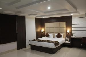 a hotel room with a large bed and a desk at Hotel Royal Heritage in Guwahati