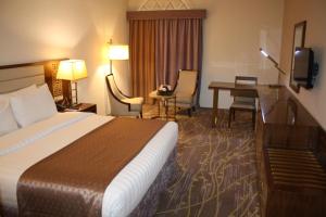 ein Hotelzimmer mit einem Bett und einem Schreibtisch in der Unterkunft Al Mutlaq Hotel Riyadh in Riad