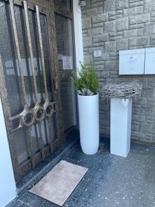 two large white vases sitting in front of a door at Gästehaus Paulina in Cochem