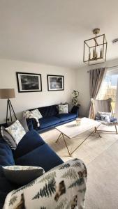 uma sala de estar com um sofá azul e uma mesa em Insch House em Kincraig