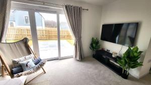 a living room with a large sliding glass door at Insch House in Kincraig