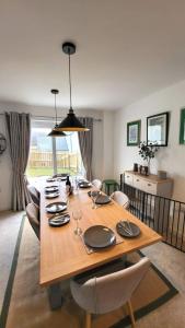 uma sala de jantar com uma mesa de madeira e cadeiras em Insch House em Kincraig