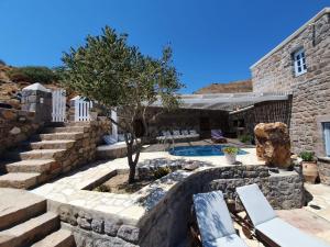 a stone house with a swimming pool and stairs at Theologos Houses in Grikos