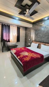 a bedroom with a large bed with a red blanket at Hotel diamond tree by dream homes group in Agra