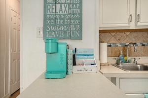 a kitchen counter with a blue coffee maker on it at Tipsea on the seawall in Galveston