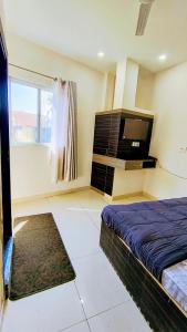 a bedroom with a bed and a flat screen tv at Hotel diamond tree by dream homes group in Agra