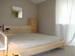 a bedroom with a wooden bed with a mirror at Alba Pura in Santa Caterina Dello Ionio Marina