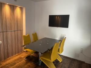 a conference room with a table and yellow chairs at Eisenstrassen Apartment in Ybbsitz