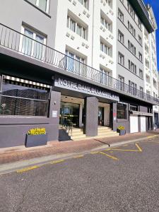 a building on a street with a parking lot at H&ocirc;tel Notre Dame de la Sarte in Lourdes