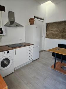 eine Küche mit einer Waschmaschine und einem Tisch in der Unterkunft Apartamentos Cuna 21 in Sevilla
