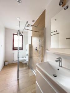 a white bathroom with a sink and a shower at Beskidian in Węgierska Górka