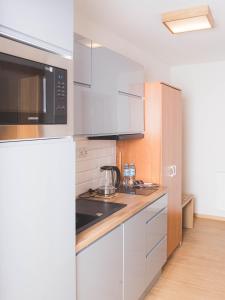 a kitchen with white cabinets and a microwave at Beskidian in Węgierska Górka