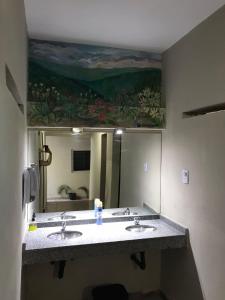 uma casa de banho com 2 lavatórios e um espelho grande em Urban Jungle Hostel em San Miguel de Tucumán
