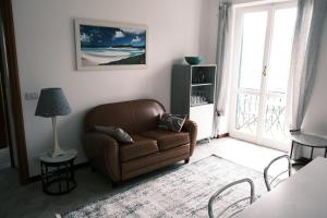 ein Wohnzimmer mit einem braunen Sofa und einem Fenster in der Unterkunft La Vigie by PortofinoVacanze in Santa Margherita Ligure