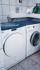 una lavatrice e asciugatrice bianche in bagno di Bory Apartman, zárt udvari parkolás a Székesfehérvár