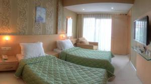 Habitación de hotel con 2 camas y sofá en Marin-A Hotel & Spa Turgutreis, en Turgutreis