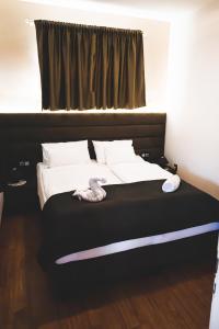 Una cama con sábanas blancas y almohadas en un dormitorio en Bory Apartman, zárt udvari parkolás, en Székesfehérvár