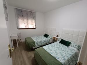 Cette chambre comprend 2 lits et une fenêtre. dans l'établissement APARTAMENTO ESTEL, à La Seu d'Urgell