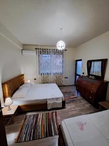 a bedroom with a bed and a flat screen tv at The house of dreams 2 in Shkodër
