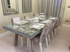 a dining room table with chairs and a glass table top at ROYAL BEACH RESIDENCES 2 in Dubai