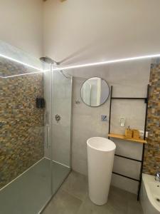 y baño con ducha, aseo y lavamanos. en Atrium, en Castellammare del Golfo