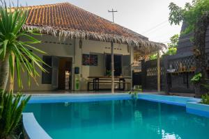 a villa with a swimming pool in front of a house at Ranasa Yogyakarta in Timuran
