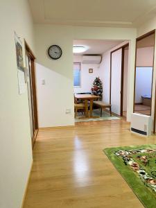 豐中的住宿－Otami Stay，客厅配有桌子和墙上的时钟