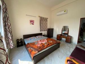 a bedroom with a bed and a chair in it at Aqua villa vedic village in kolkata