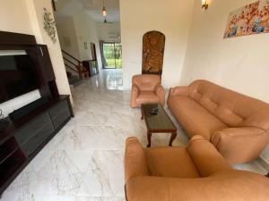 a living room with couches and a flat screen tv at Aqua villa vedic village in kolkata