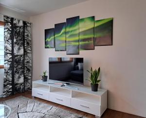 a living room with a tv on a wall at Elice Apartment in Rovaniemi