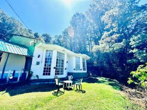 a table and chairs in front of a house at Lakeside Cottage by Clover in Nuwara Eliya