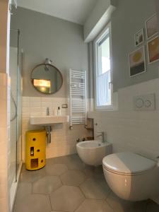 ein Badezimmer mit einem WC, einem Waschbecken und einem Spiegel in der Unterkunft The Silky Way in Como