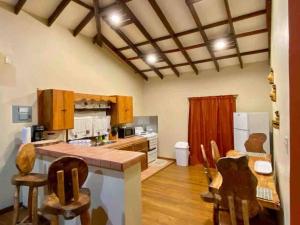 a kitchen with a counter and some chairs in it at Casa Café Roatan, Honduras in Punta Blanca +11 photos