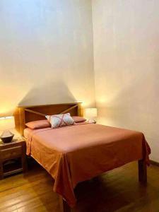 a bedroom with a bed with a orange bedspread at Casa Café Roatan, Honduras in Punta Blanca