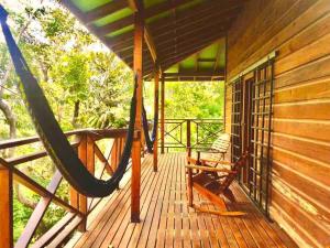 a porch with a hammock on a cabin at Casa Café Roatan, Honduras in Punta Blanca