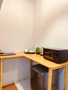 a microwave sitting on top of a wooden table at De Bali à Conaky *KIPE* in Conakry