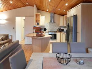 a kitchen and living room with a couch and a table at Loch Lomond Sanctuary Lodges in Balloch