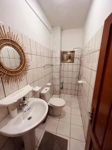 ein Badezimmer mit einem Waschbecken, einem WC und einem Spiegel in der Unterkunft De Bali à Conaky *KIPE* in Conakry