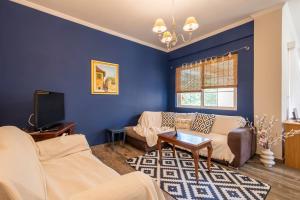 ein blaues Wohnzimmer mit einem Sofa und einem TV in der Unterkunft Live Like a Local in Nafplio