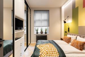 - une chambre avec un lit et une télévision à écran plat dans l'établissement Lion Apartments - New Sopot by the sea!, à Sopot